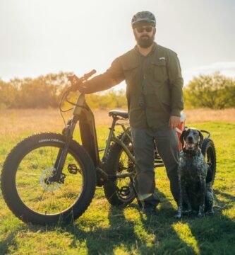 a man standing next to a bike and a dog