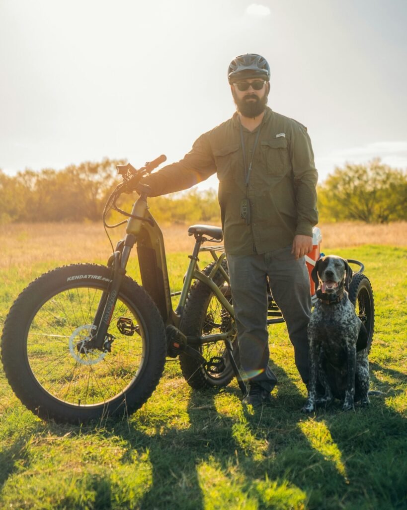 a man standing next to a bike and a dog